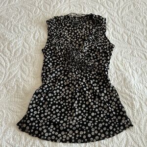 Sleeveless top with V neck. Darling rosettes at neckline.